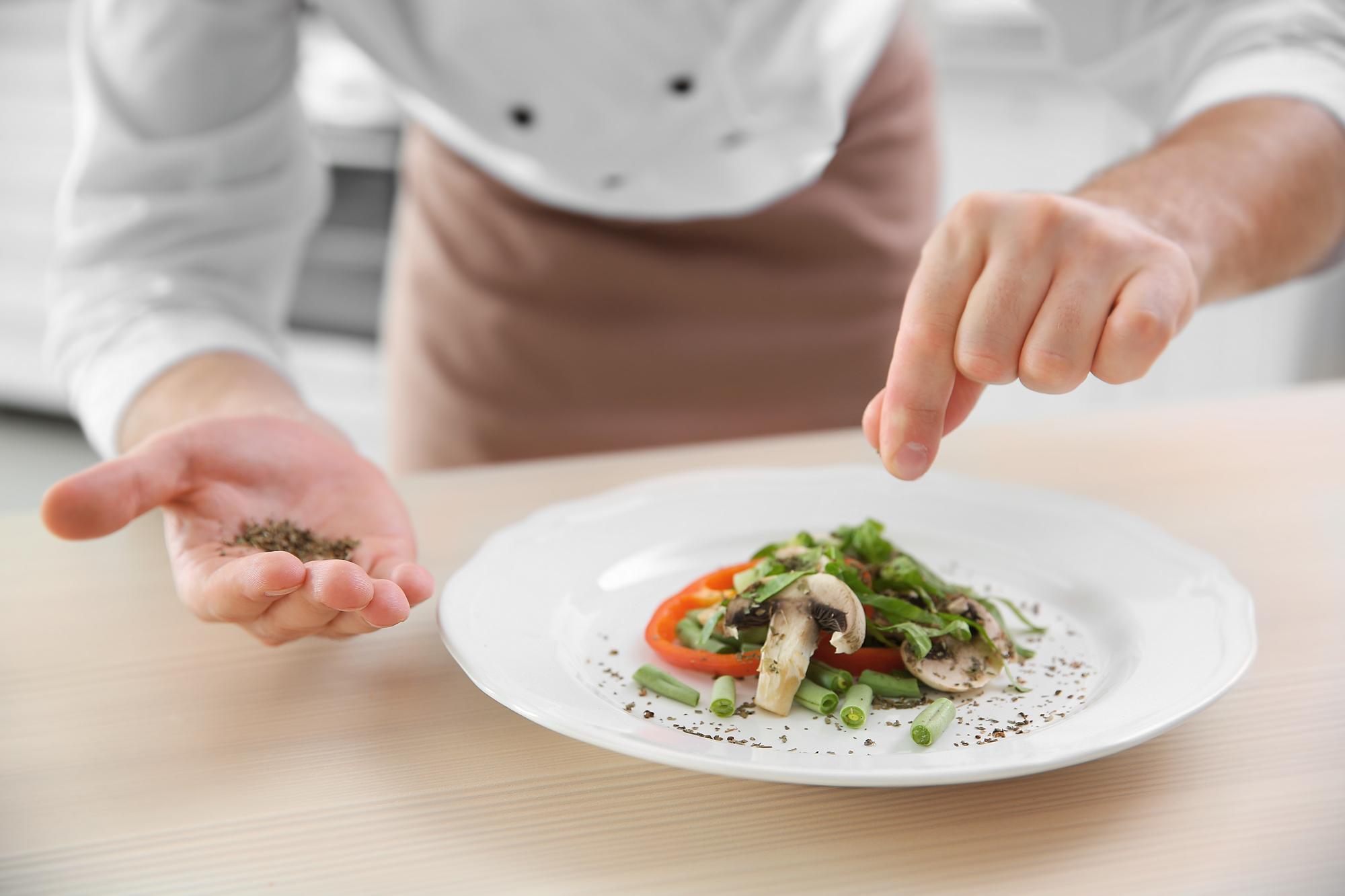 Chef preparing plated dish on wooden counter